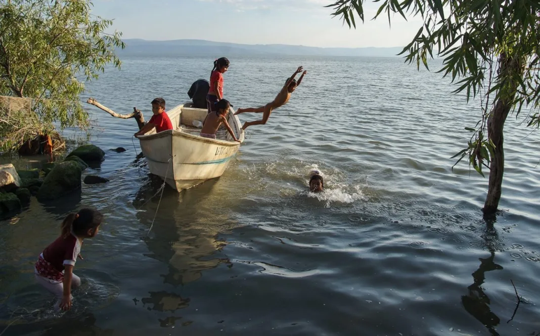 Pequeños de Agua Caliente juegan en la orilla del Lago