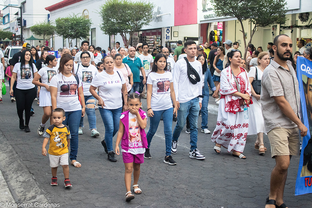 Madres buscadoras de Colima caminan en peregrinación con mantas y fotografías de personas desaparecidas