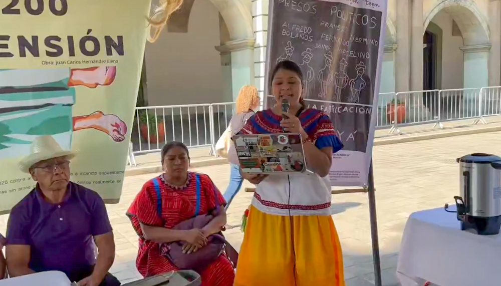 Argelia Betanzos, activista de Eloxochitlán de Flores Magón, anuncia la anulación de 200 órdenes de aprehensión ilegales contra defensores en una conferencia de prensa.