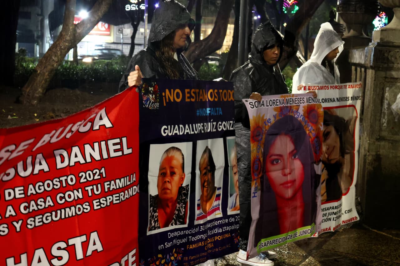 Familias buscadoras marchan en la Ciudad de México con fotografías de personas desaparecidas durante una velada