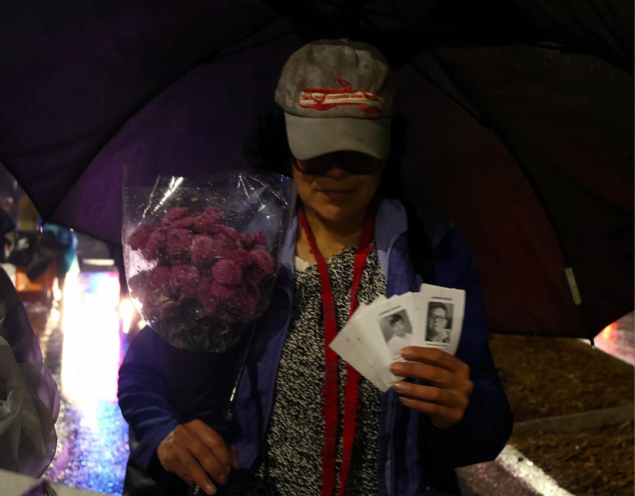 Familias buscadoras marchan en la Ciudad de México con fotografías de personas desaparecidas durante una velada